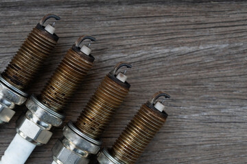 Old spark plugs on the wooden table background.