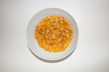 Corn flakes cereal on ceramic bowl with white background