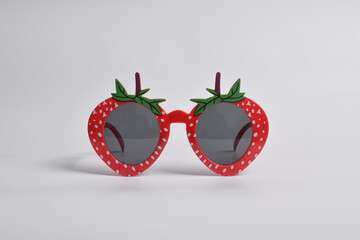 Red strawberry glasses on white background. For a birthday, disco party, carnival, festival
