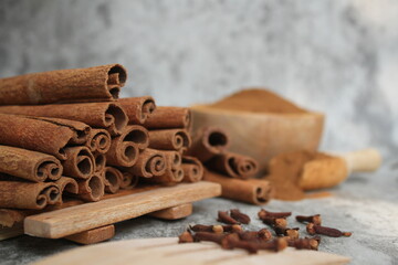 Wooden bowl with cinnamon sticks and anise on table