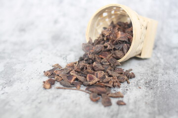 star anise in a wooden bowl on the table, close up