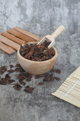 star anise in a wooden bowl on the table, close up