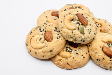 Stack of Whole Grain Cookies with different seeds, cashew nuts, almond, black sesame, pumpkin seed on white background