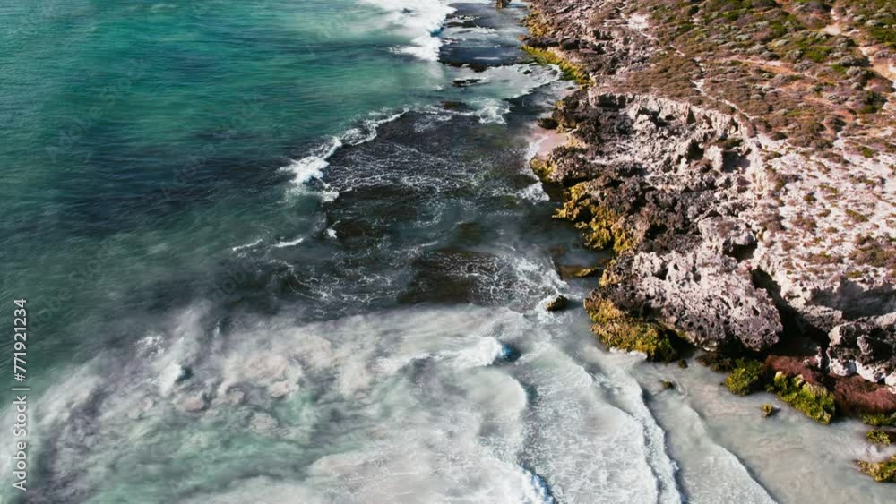 Poster an expansive view from above capturing the contrast between rugged coastline and the clear, turquois