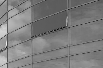 Dark grey glass reflects cloudy sky modern building facade exterior office texture background