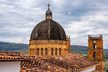 Historic church with black dome and ornate tower in Barichara, Santander, Colombia under a cloudy...