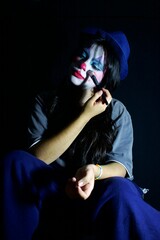 seated girl wearing clown make-up
