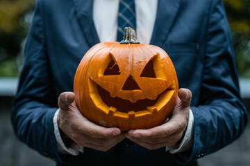A businessman showcasing a pumpkin in the spirit of the Halloween holiday