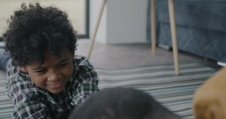 Slow motion of cute little boy competing with father in arm wrestling enjoying game with dad at home. Childhood and sports concept.