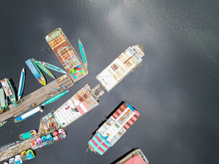 Tourist boats are parked at the Kereng Bengkirai pier as seen from the air. Kereng Bengkirai is a tourist destination in the Sebangau national park area, Palangkaraya, Central Kalimantan, Indonesia. - obrazy, fototapety, plakaty