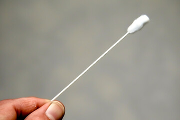 Person using a cotton swab with plastic stem