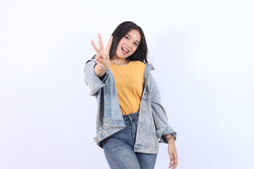 Young beautiful Asian woman wearing blue jacket yellow t-shirt showing number 3 and pointing up...
