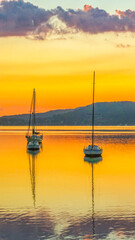 Autumn sunrise over the bay with boats and reflections