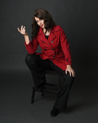 full length portrait of beautiful brunette woman model, wearing red trench coat jacket with black...
