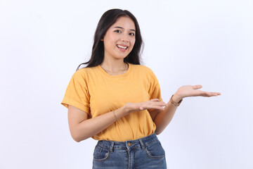Happy young Asian woman wearing  yellow t-shirt presenting or showing open hand palm with copy...