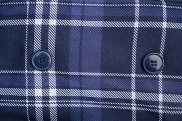 Fabric with blue and white crossed lines and buttons. Textile texture.