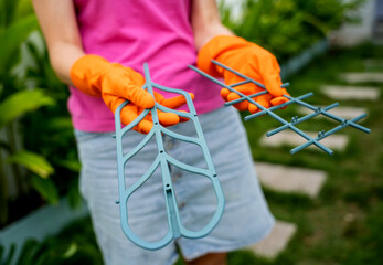 A young woman takes care of the garden and tying up plants