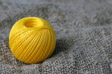 A skein of yellow thread on canvas. Yarn, ball, thread, fluffy, ball, handmade, craft, object, woolen, skein, material, homemade, hobby, traditional, creative