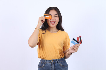 Excited Asian woman holding credit cards. Happy model girl wear casual t-shirt clothes showing...