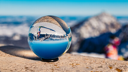 Crystal ball alpine winter landscape shot at Mount Fuessener Joechle, Graen, Reutte, Tyrol, Austria