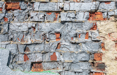 Destroyed brickwork with elements of plaster and paint as an abstract background.