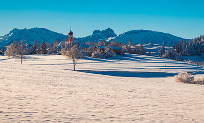 Alpine winter wonderland view with a church near Seeg, Ostallgaeu, Bavaria, Germany