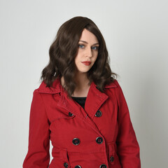 head and shoulders close up portrait of beautiful brunette woman model, wearing red trench coat...