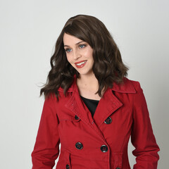 head and shoulders close up portrait of beautiful brunette woman model, wearing red trench coat jacket . expressive emotive facial expressions, smiling.  isolated on white studio background.