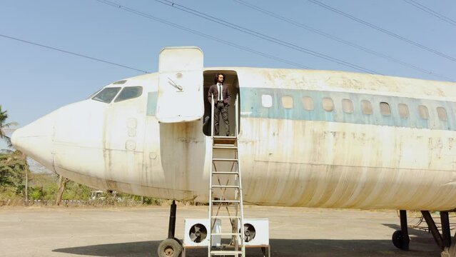 Man walking standing on a plane door and looking