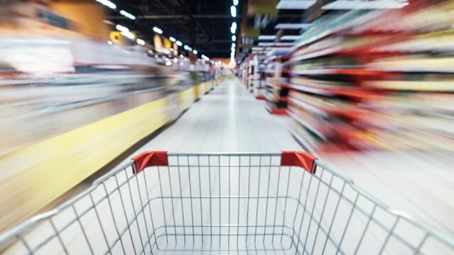 Time lapse of shopping trolley rushing inside supermarket full of food products and people. Retail store and consumerism concept. - Powered by Adobe