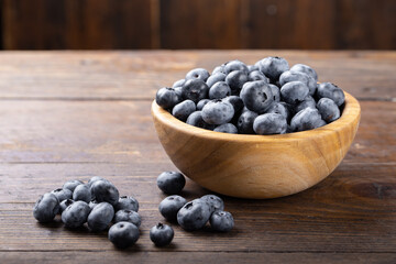 Fresh blueberry in wooden bowl. Concept of healthy and dieting eating.