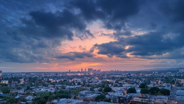 Dramatic rainy storm clouds flying over twilight Los Angeles cityscape, featuring Century City skyline at sunset. Aerial hyperlapse timelapse.