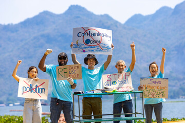 Team of ecologist volunteers are demonstrating rally at ocean for climate change and saving nature with protest sign against pollution and sea contamination for wildlife and biodiversity