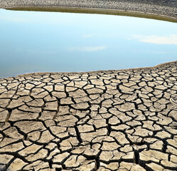 Drying lake. Landscape with a lake and cracked soil on the shore