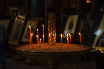 Burning candles in front of icons