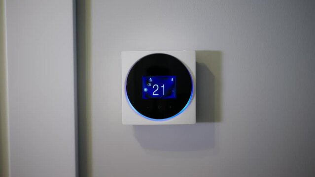 Setting the temperature in the room. Setting the house temperature via the thermostat. Setting the thermostat manually. Air conditioner. Digital thermostat. Hotel. Remote control thermostat. The man