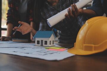 A team of construction engineers talks to managers and construction workers at the construction site. Quality inspection, work plan, home and industrial building design project