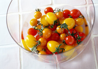 Red and yellow tomatoes in glass bowl