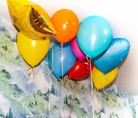 Colorful balloons close-up on the background of the wall and ceiling of the room