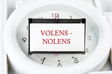 Willy - nilly latin expression volens-nolens (willing or unwilling) written on a white business card