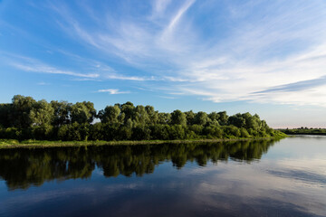 Fototapeta na wymiar European landscape, river, blue sky on a background of green trees.