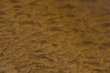 Background of river sand under water with wave sediment.