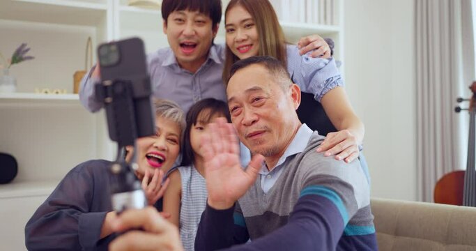 Happy family captures a joyful moment together with a selfie using a smartphone in their cozy living room.