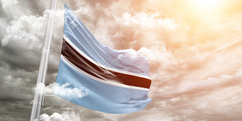 Botswana national flag cloth fabric waving on beautiful cloudy Background.
