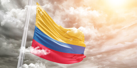 Colombia national flag cloth fabric waving on beautiful cloudy Background.