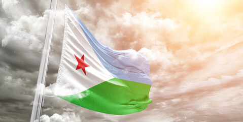 Djibouti national flag cloth fabric waving on beautiful cloudy Background.