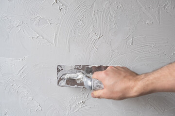 Applying decorative putty. White abstract texture of surface covered with putty. textured...