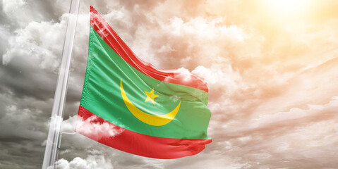 Mauritania national flag cloth fabric waving on beautiful cloudy Background.