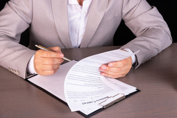 Businessman sitting at office desk signs a contract.