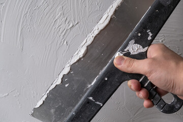 Applying decorative putty. White abstract texture of surface covered with putty. textured...